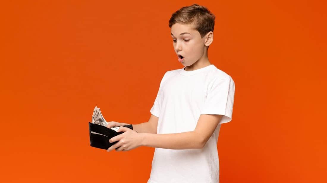 wallets for teenage guys - image of shocked boy with lots of cash in his wallet