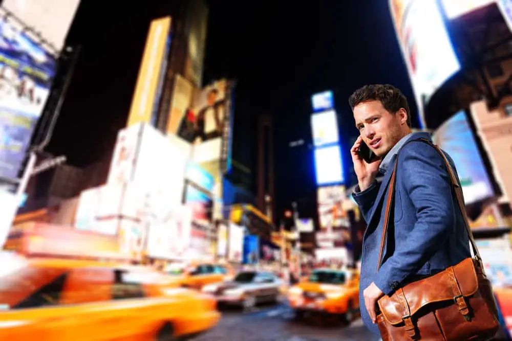 business man in New York with cellphone and messenger bag