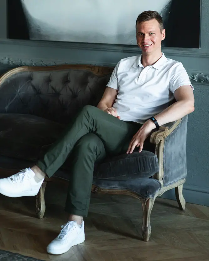 Article: What to wear with Olive Green Pants Image shows seated man in olive green pants and white polo