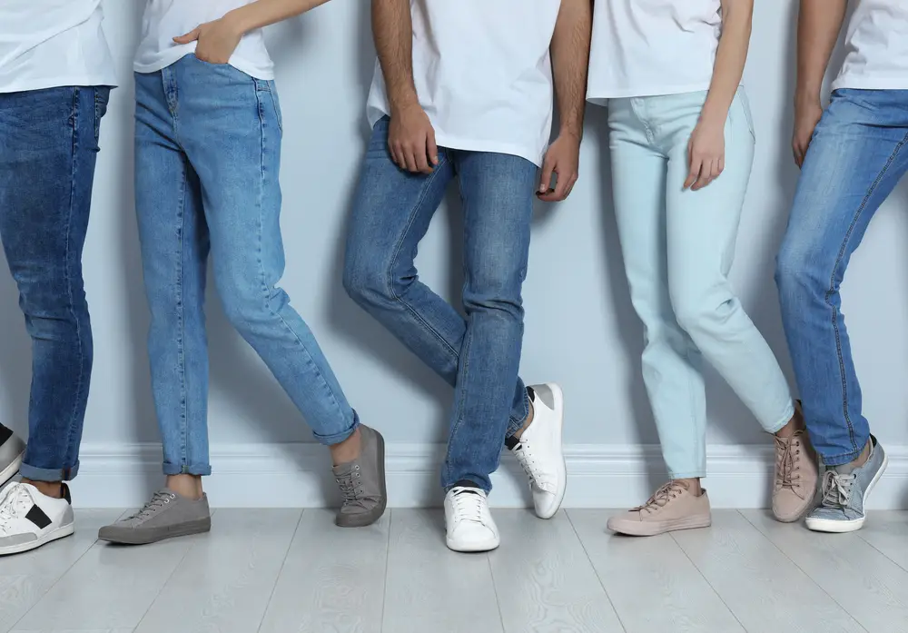 Article: What to wear with light blue jeans Image shows a group of young people all wearing jeans against a light wall