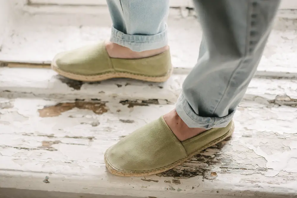 man with light blue jeans and not new green espadrilles