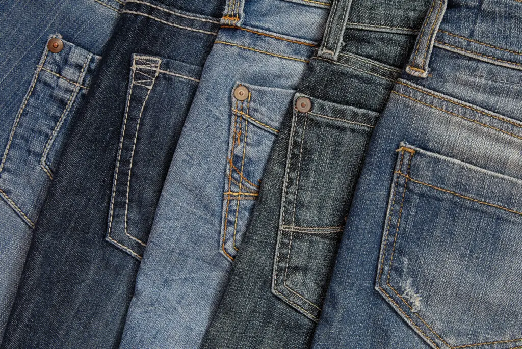 Article: What to wear with gray jeans? Image shows a pile of jeans